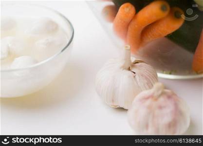 food, healthy eating, cooking and objects concept - close up of garlic, carrot and mozzarella cheese