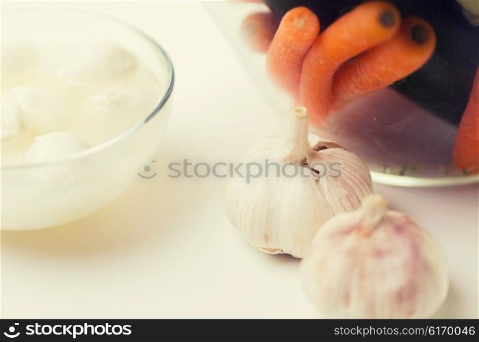 food, healthy eating, cooking and objects concept - close up of garlic, carrot and mozzarella cheese