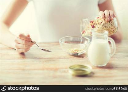 food, healthy eating, people and diet concept - close up of woman eating muesli with milk for breakfast