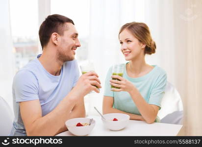 food, home, couple and happiness concept - smiling couple having breakfast at home