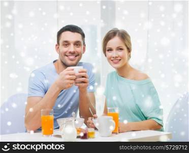 food, home, people and happiness concept - smiling couple having breakfast at home