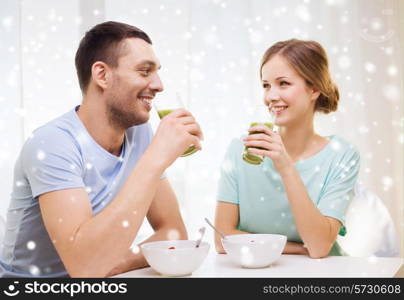 food, home, people and happiness concept - smiling couple having breakfast at home