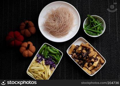 Food ingredients for dry rice vermicelli fried with vegetables from top view, a Vietnamese vegetarian dish for vegans, a dish can make quick for breakfast at home from noodle, vegetable, mushroom, tofu