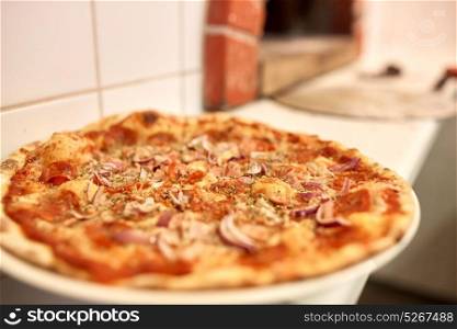food, italian kitchen, culinary and cooking concept - baked pizza at pizzeria. baked pizza at pizzeria