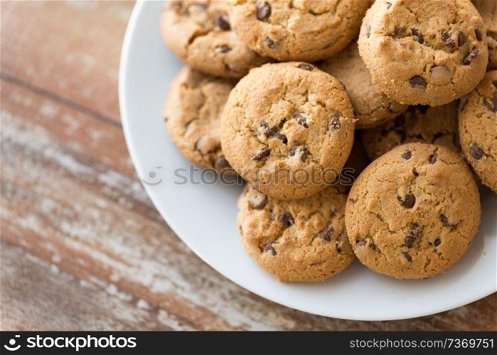 food, junk-food and eating concept - close up of oatmeal cookies with chocolate chips on plate. close up of oatmeal cookies on plate