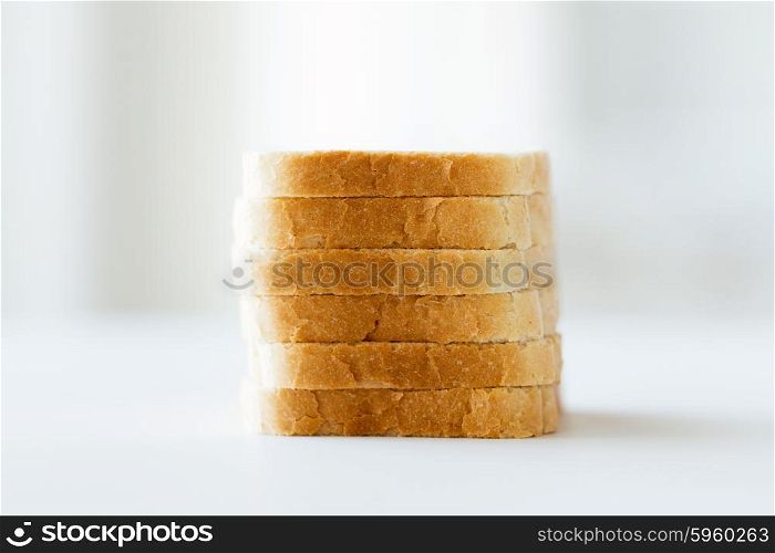 food, junk-food and unhealthy eating concept - close up of white sliced toast bread pile on table