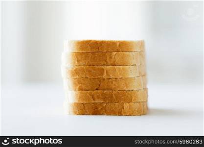 food, junk-food and unhealthy eating concept - close up of white sliced toast bread pile on table