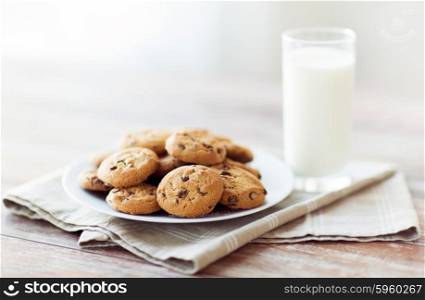 food, junk-food, culinary, baking and eating concept - close up of chocolate oatmeal cookies and milk glass on plate