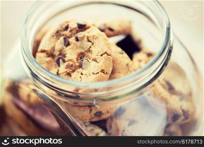 food, junk-food, culinary, baking and eating concept - close up of chocolate oatmeal cookies in glass jar