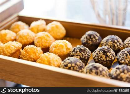 food, junk-food, culinary, baking and eating concept - close up of sweets or muffins on wooden tray or box
