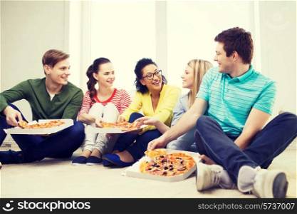 food, leisure and happiness concept - five smiling teenagers eating pizza at home