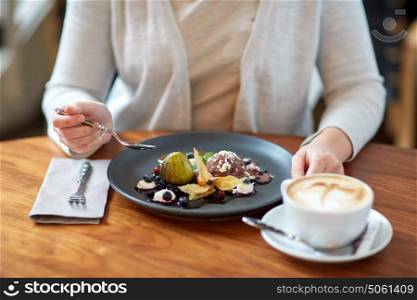food, new nordic cuisine and people concept - woman eating chocolate ice cream dessert with blueberry kissel, honey baked fig and greek yoghurt with coffee at cafe. woman eating ice cream dessert with coffee at cafe