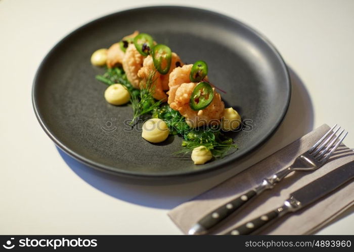 food, new nordic cuisine, culinary and cooking concept - close up of king prawns with jalapeno, wasabi mayonnaise and wakame salad on plate