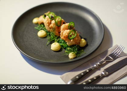 food, new nordic cuisine, culinary and cooking concept - close up of king prawns with jalapeno, wasabi mayonnaise and wakame salad on plate