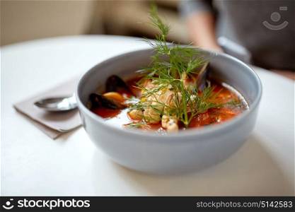 food, new nordic cuisine, culinary and cooking concept - seafood soup with fish and blue mussels in bowl at restaurant. seafood soup with fish and blue mussels in bowl