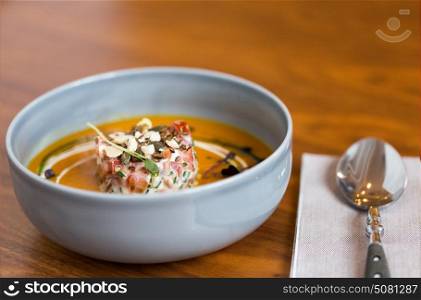 food, new nordic cuisine, culinary and cooking concept - vegetable pumpkin-ginger soup with goat cheese and tomato salad with yogurt in bowl. vegetable pumpkin-ginger soup in bowl