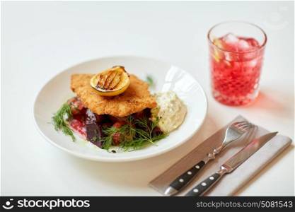 food, new nordic cuisine, dinner, culinary, haute cuisine and cooking concept - close up of breaded fish fillet with tartar sauce and oven-baked beetroot tomato salad on plate. close up of fish salad with roasted lemon on plate