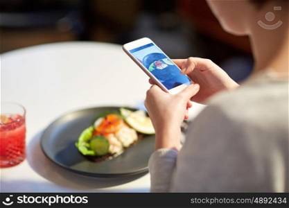 food, new nordic cuisine, technology and people concept - close up of woman with smartphone photographing toast skagen with shrimps, lemon mayonnaise, caviar and buttery bread at restaurant