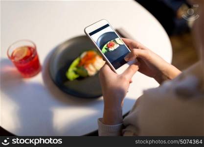 food, new nordic cuisine, technology and people concept - woman with smartphone photographing toast skagen with shrimps, caviar and buttery bread at restaurant. woman with smartphone photographing food at cafe