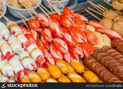food on the streets of asia - crab claws and grilled sausages close-up
