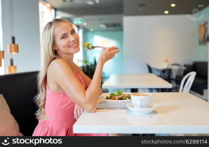 food, people and leisure concept - happy young woman eating salad with coffee for lunch at restaurant. happy young woman eating lunch at restaurant