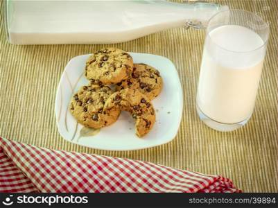 Food photography with a couple of delicious cookies on a plate and a glass of milk on the side