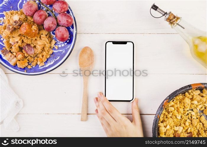 food plates hand with mobile phone cooking table