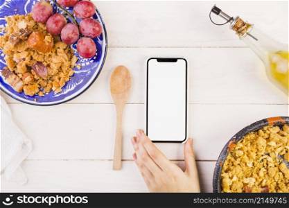 food plates hand with mobile phone cooking table