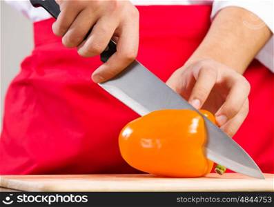 Food preparing. Close up of cook hands cutting pepper