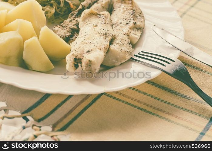 Food. Ready delicious dinner fish meat with salad and potatoes on kitchen home table. Meal time. Indoor.. Dinner meal fish with salad and potatoes
