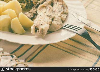Food. Ready delicious dinner fish meat with salad and potatoes on kitchen home table. Meal time. Indoor.. Dinner meal fish with salad and potatoes