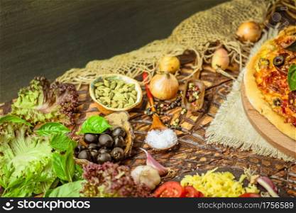 Food ready for cooking. Pizza ingredients on table. Ingredients with pizza dough. Basil and ingredients for pizza. Copy space for your text. Pizza with ingredients and spices. Pizza on wooden board and various cook ingredients.