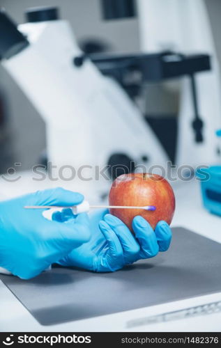 Food Safety Laboratory Analysis - Biochemist looking for presence of pesticides in apples. Food Safety Laboratory Analysis - Biochemist looking for presence of pesticides in apples
