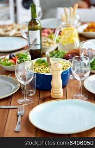 food, seasoning and eating concept - pepper mill or salt grinder on served wooden table. pepper mill or salt grinder on table with food