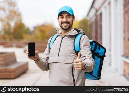 food shipping, profession and people concept - happy smiling delivery man with smartphone and thermal insulated bag in city showing thumbs up. delivery man with phone and thermal bag in city