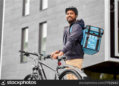 food shipping, profession and people concept - happy smiling delivery man with thermal insulated bag and bicycle on city street. food delivery man with bag and bicycle in city
