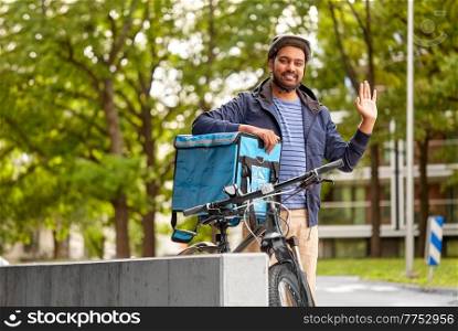 food shipping, profession and people concept - happy smiling delivery man with thermal insulated bag and bicycle on city street. delivery man with food bag and bicycle in city