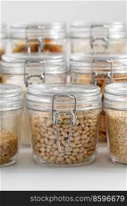 food storage, culinary and storage concept - jars with different cereals or groceries on table. jars with cereals or groceries on table