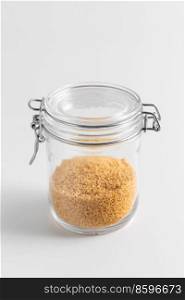 food storage, eating and cooking concept - jar with bulgur on white background. close up of jar with bulgur on white table