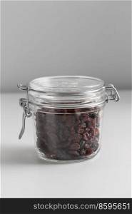 food storage, healthy eating and diet concept - close up of jar with raisin on white background. close up of jar with raisin on white table