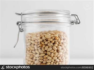 food storage, healthy eating and diet concept - close up of jar with dried peas on white background. close up of jar with dried peas on white table