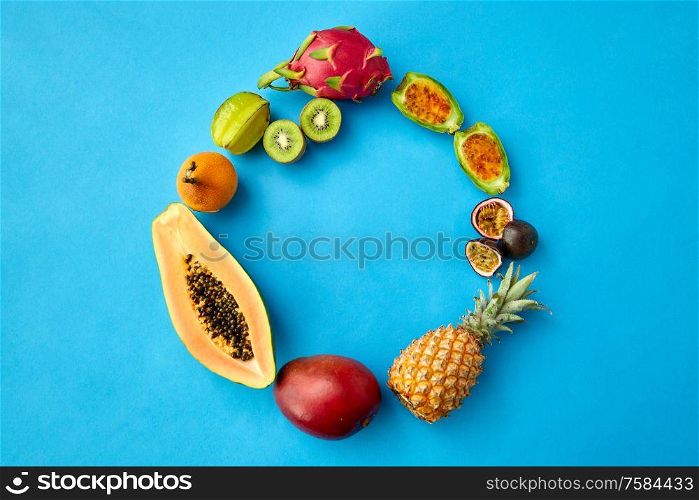 food, summer and healthy eating concept - different exotic fruits on blue background. different exotic fruits on blue background