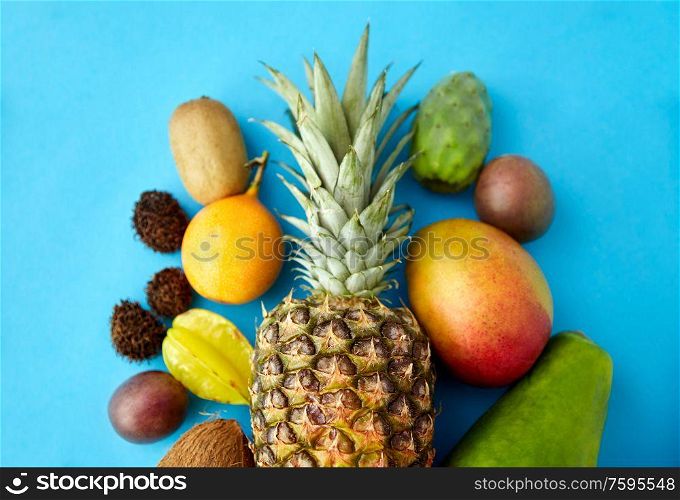 food, summer and healthy eating concept - many different exotic on blue background. many different exotic fruits on blue background