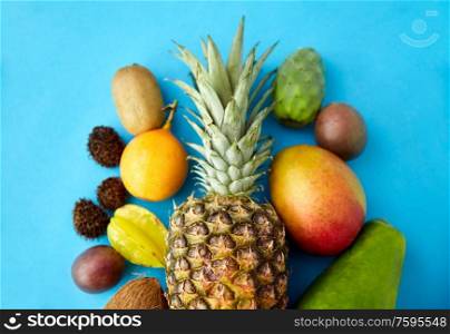 food, summer and healthy eating concept - many different exotic on blue background. many different exotic fruits on blue background