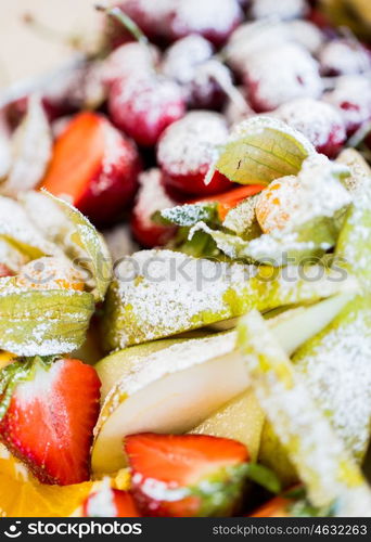 food, sweets and holidays concept - close up of dish with sugared fruit dessert