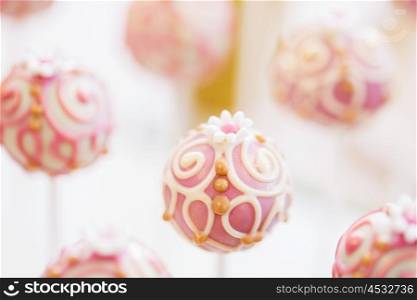 food, sweets, junk-food, confectionery and eating concept - close up of cake pops or lollipops