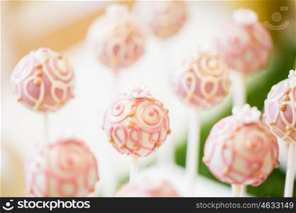 food, sweets, junk-food, confectionery and eating concept - close up of cake pops or lollipops