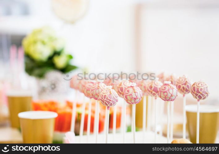 food, sweets, junk-food, holidays and celebration concept - close up of cake pops or lollipops on party table