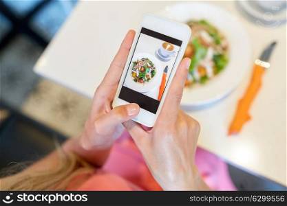 food, technology, eating and people concept - woman with smartphone photographing salad at restaurant. woman with smartphone photographing food at cafe