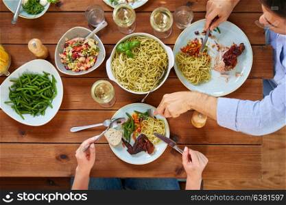 food, thanksgiving day and leisure concept - people eating pasta and chicken for dinner. couple at table with food eating pasta and chicken